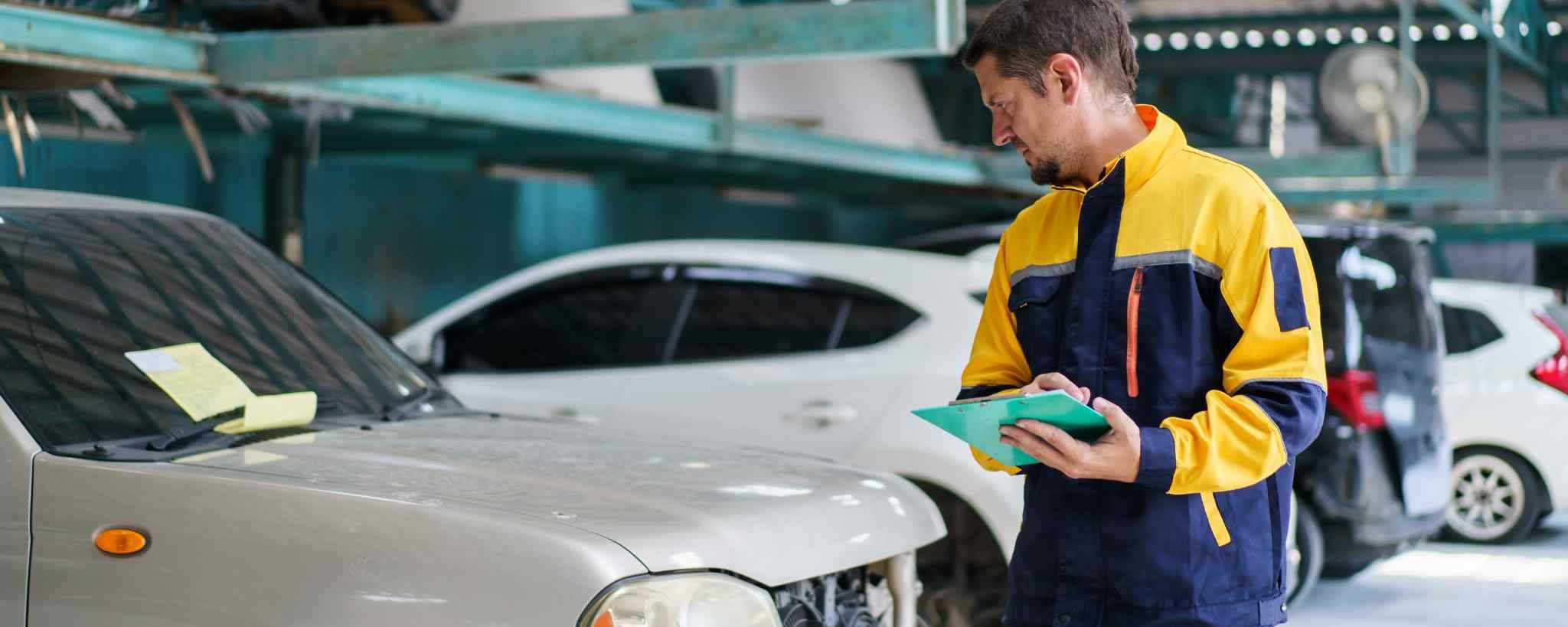 Man inspecting a car with a car maintenance checklist